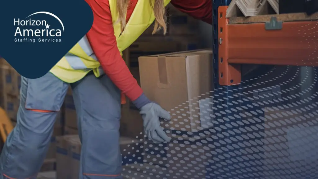 Warehouse worker in safety vest and gloves lifts a sealed box