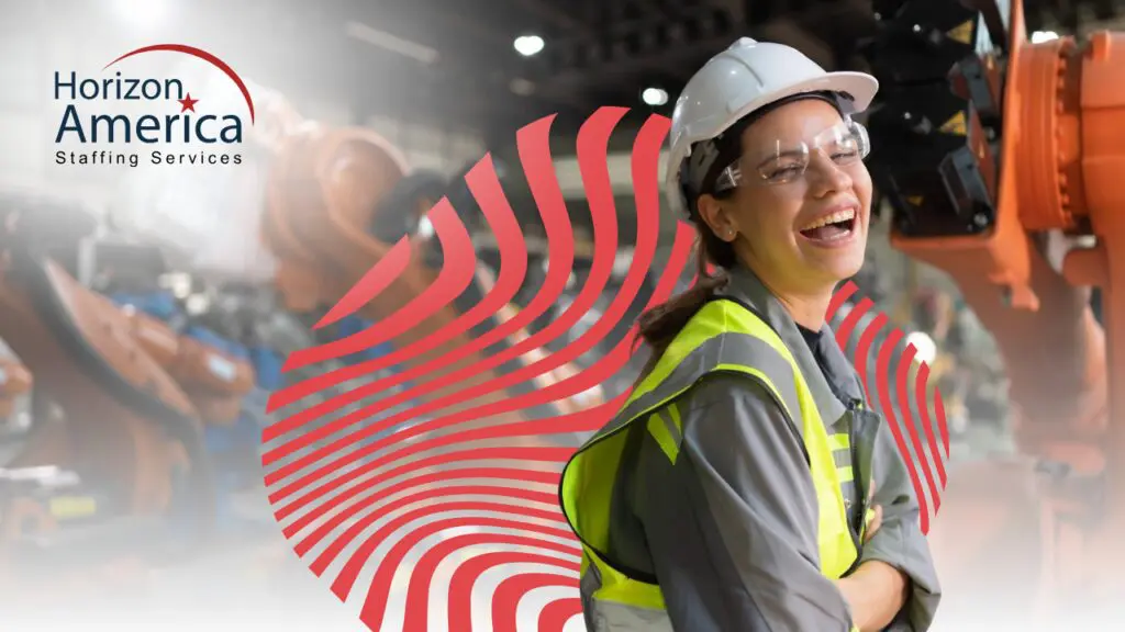 Laughing woman in safety hat and vest in her manufacturing plant
