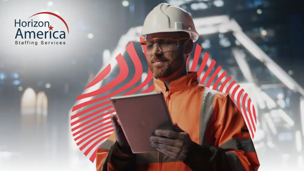 Worker in protective equipment looks on a tablet trying to evaluate light industrial job offers