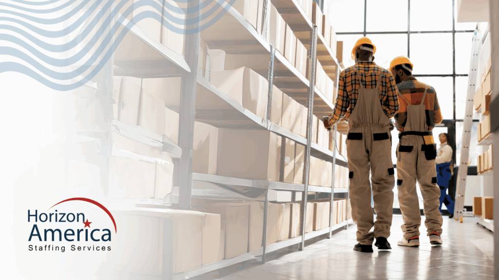 Two light industrial workers stand in a warehouse.