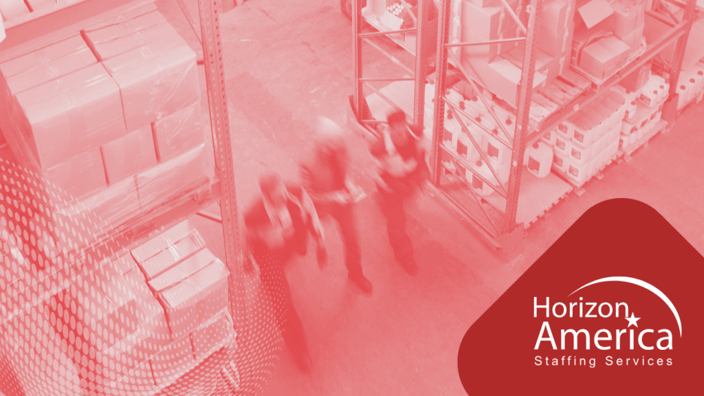 Three light industrial employees walk through a warehouse