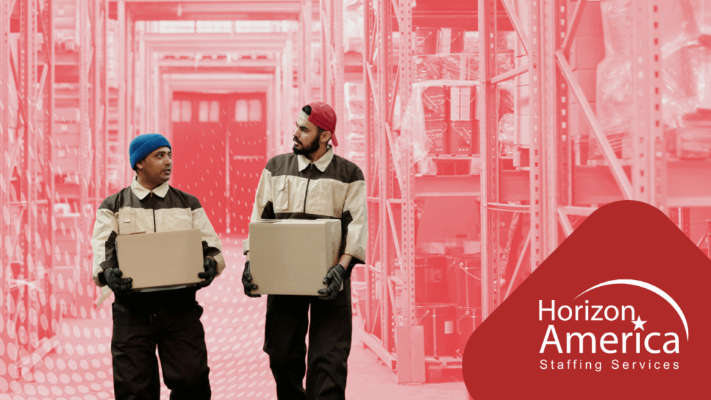 Two warehouse workers walk while carrying boxes and talking