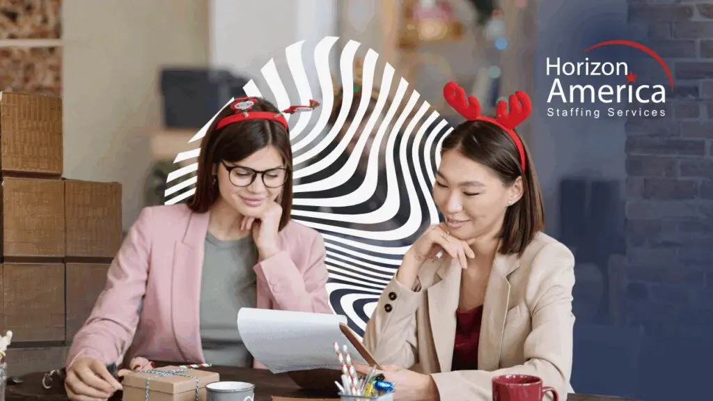 Two employees work while wearing Christmas-themed headbands