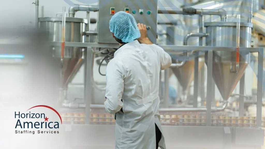 A food processing employee operates machinery in a plant.