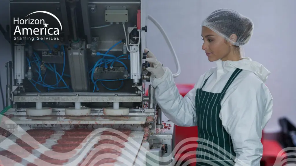 A food manufacturing worker operates machinery in a food processing plant, representing diagnostic staffing in food manufacturing.