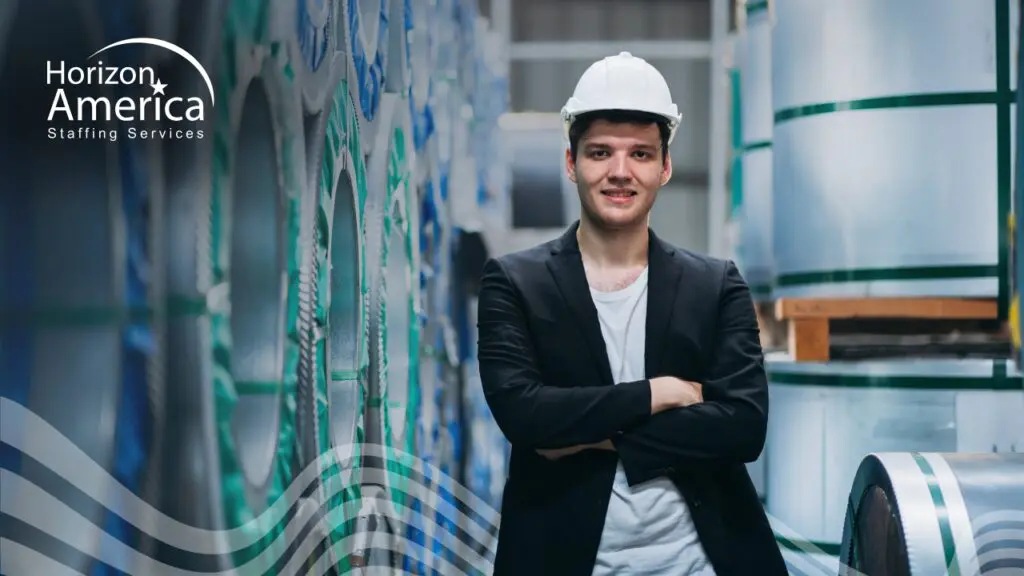 Logistics professional wearing a hard hat and blazer stands confidently, symbolizing career growth paths in logistics