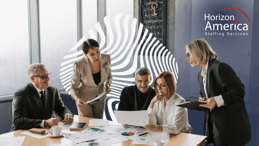 Executives gather around charts and graphs on a table for a year-end review.
