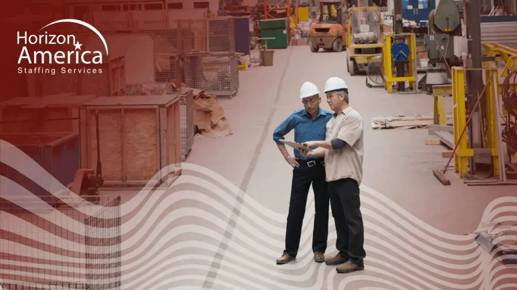 Two warehouse workers stand in their workplace talking about warehouse applicants' expectations 