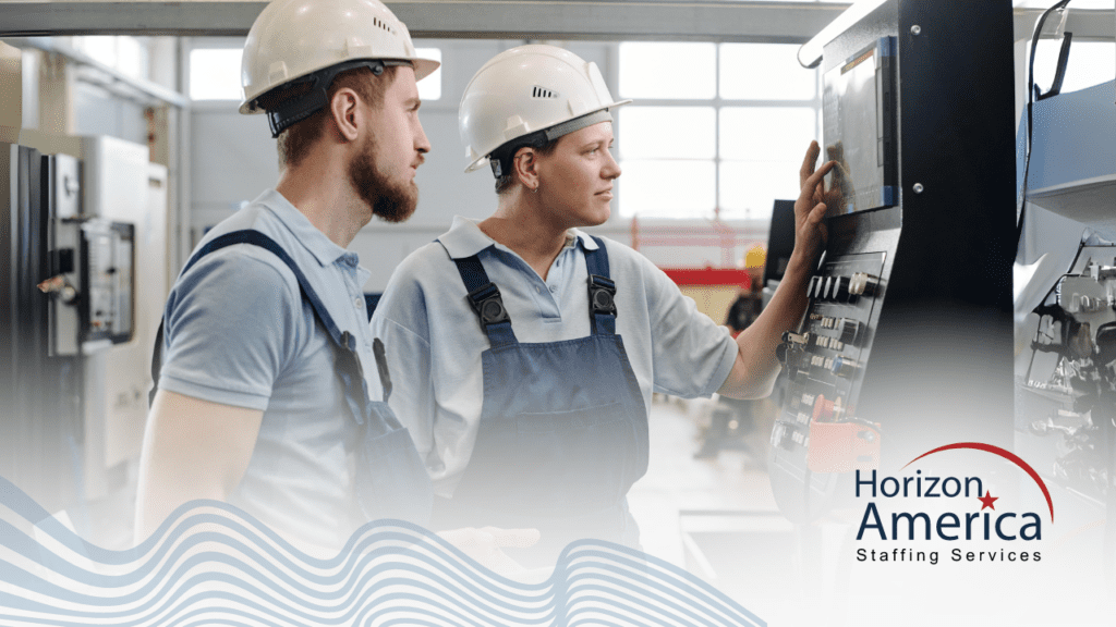 Two workers wearing safety helmets and overalls operate industrial machinery