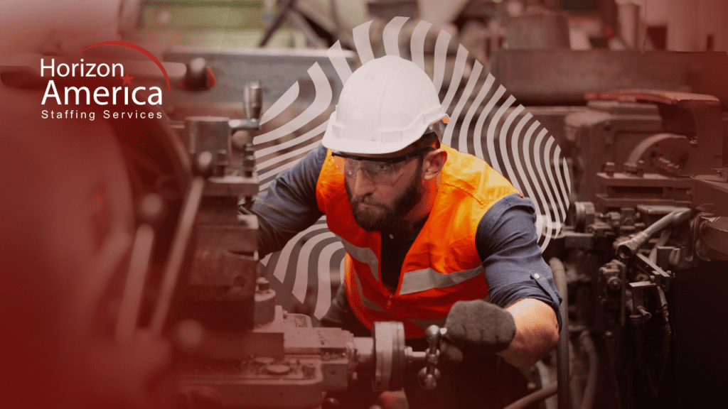 Man in hard hat and safety vest operating manufacturing machinery