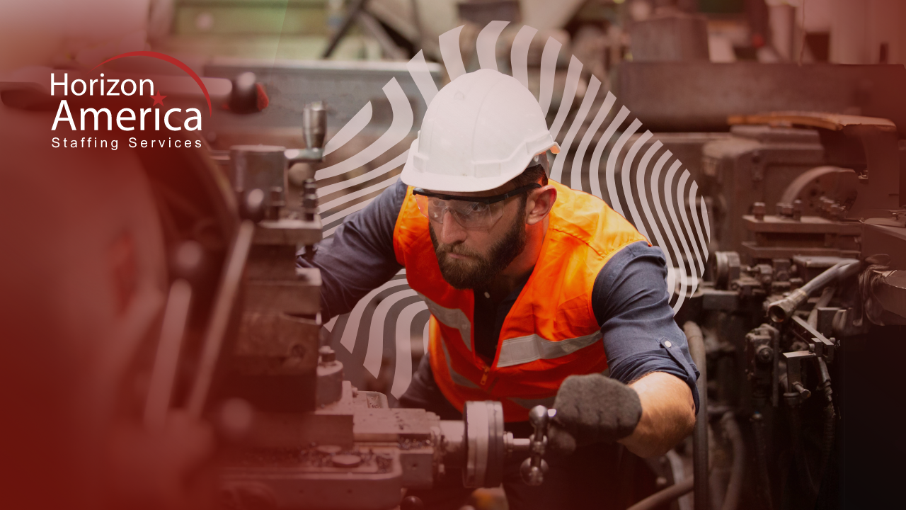 Man in hard hat and safety vest operating manufacturing machinery