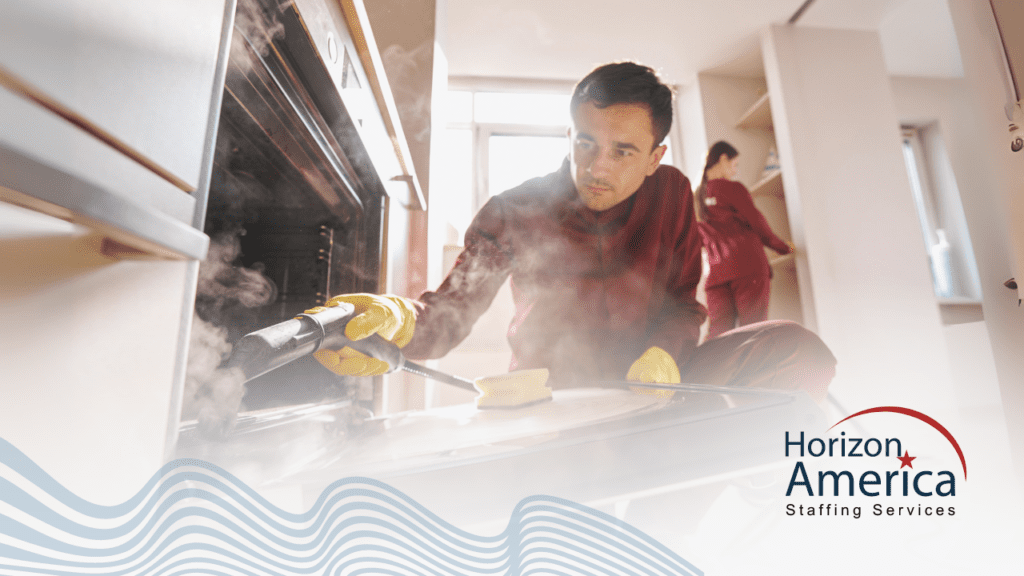 Two sanitation workers deep cleaning a kitchen