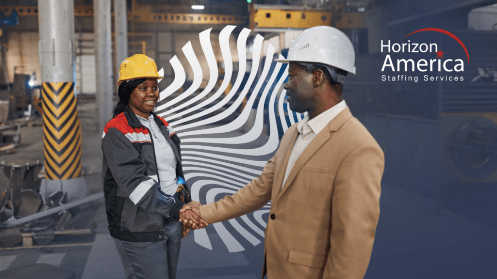 Manufacturing manager and employee in hard hats shake hands