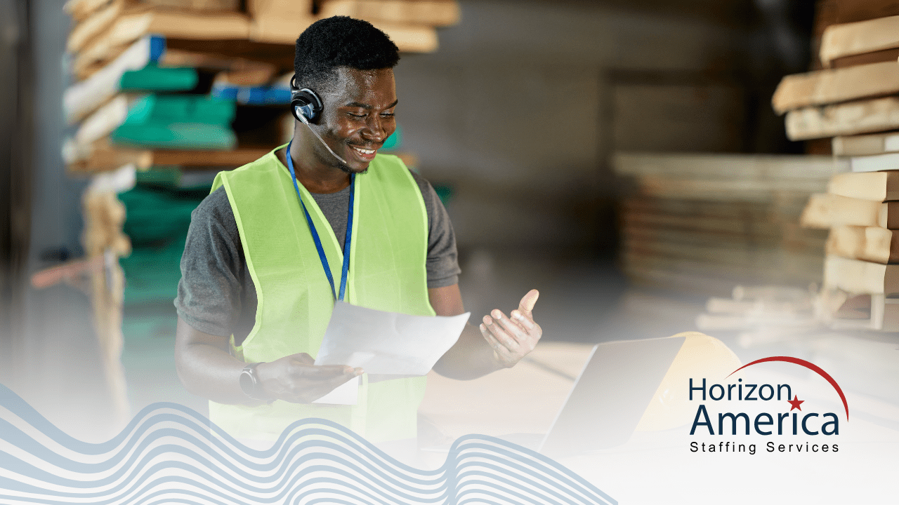 Smiling employee wearing safety vest and headset holding a paper