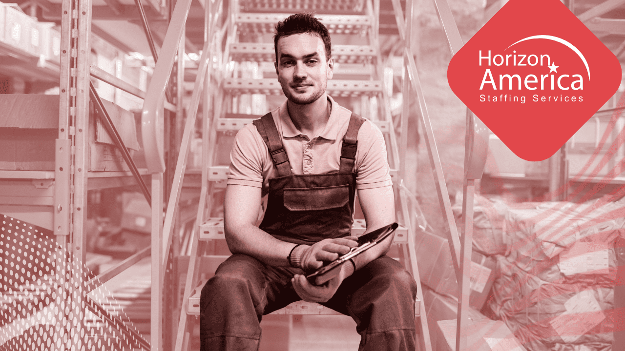 Man in overalls and gloves sits on a staircase holding a clipboard