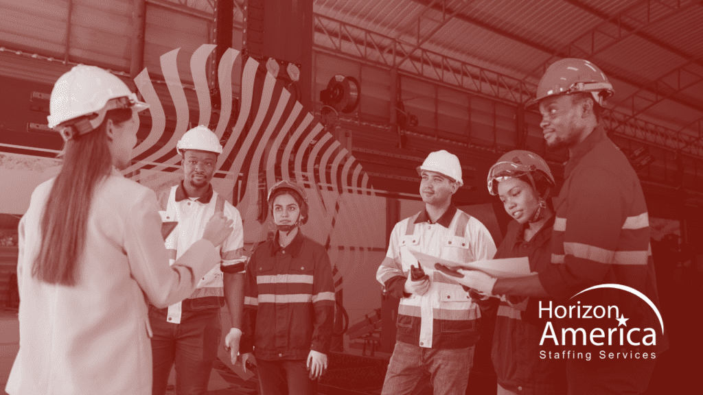 Employer in a hard hat speaks to a group of light industrial workers